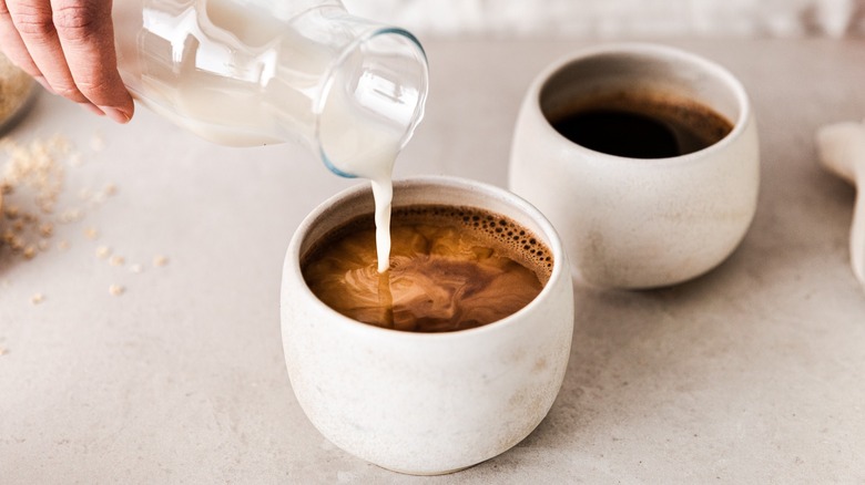 Pouring milk into a cup of coffee