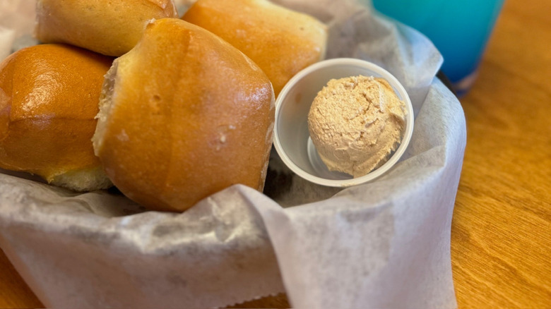 A basket of bread rolls with a whipped cinnamon butter