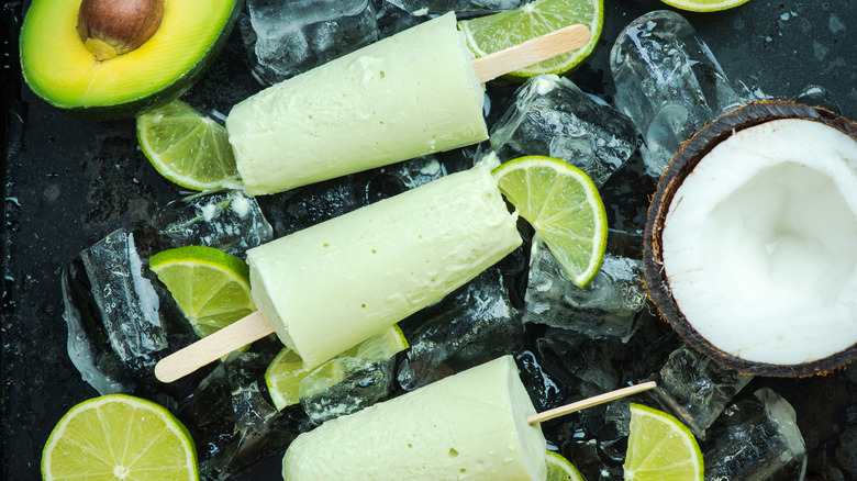avocado, lime and lemon wedges, half a coconut, and 3 light green popsicles