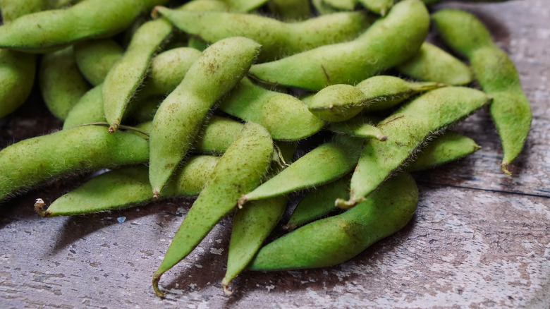 edamame in pods on a brown table