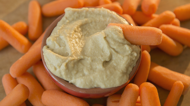 A bowl of hummus with carrots