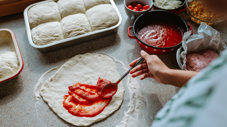 Person making pizza