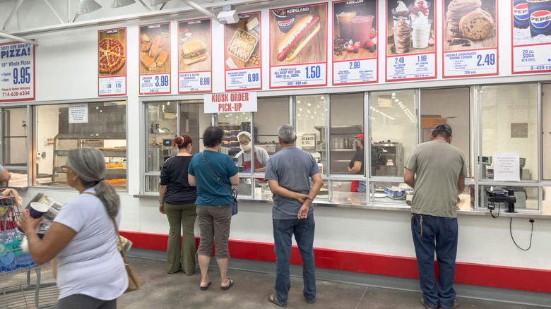 People waiting in line at a Costco food court.