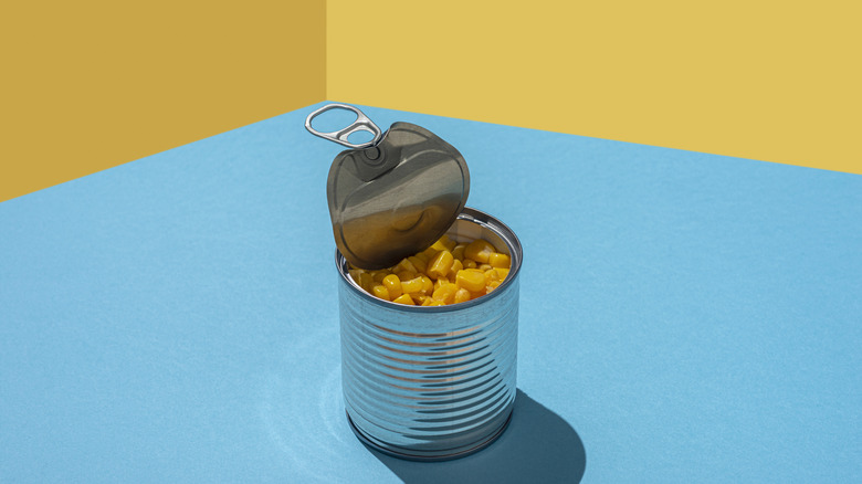 Opened can of corn in front a colorful background