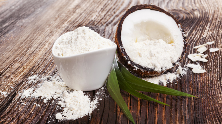 Coconut filled with coconut flour on wooden table