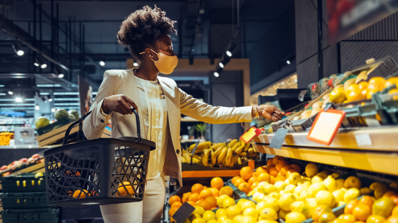 Woman in mask shopping for food