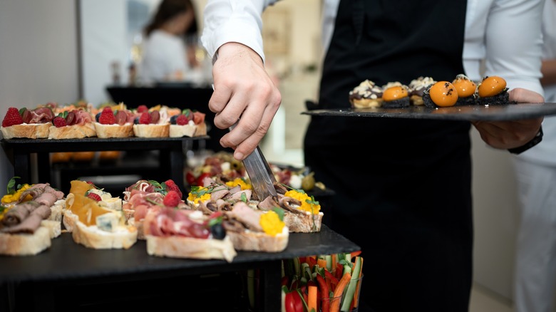 Person grabs an appetizer from a buffet