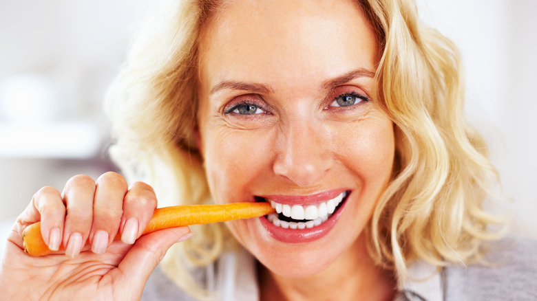 happy woman eating carrot