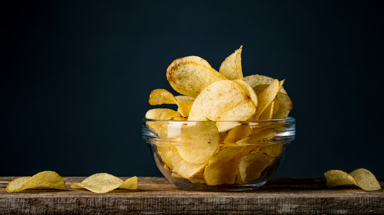 potato chips in a bowl on a wood table