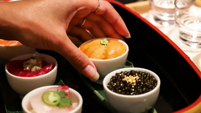 Hand selecting sushi bowl