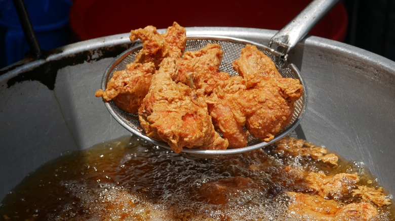 Fried chicken being lifted out of oil