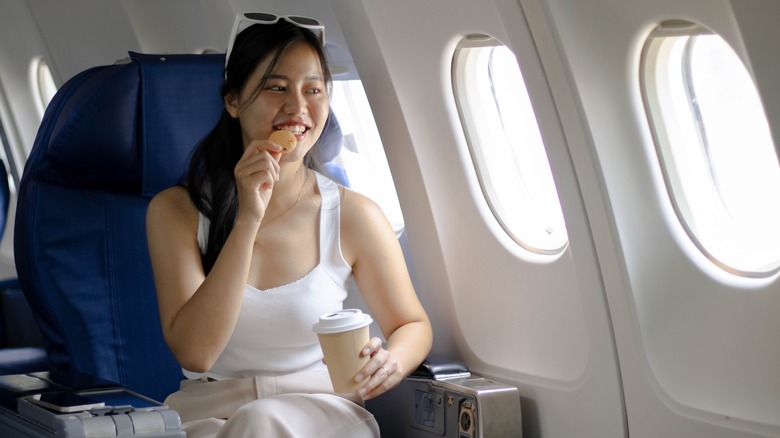 woman on a plane eating a snack