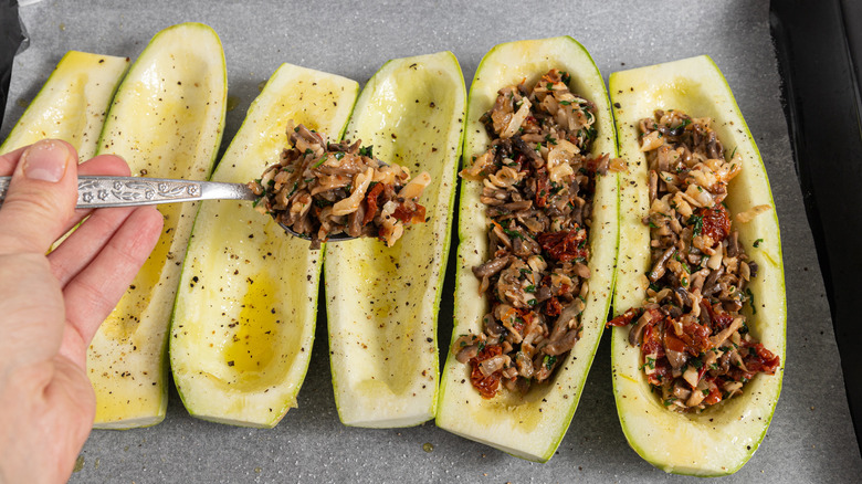 Adding a mushroom filling to zucchini boats.