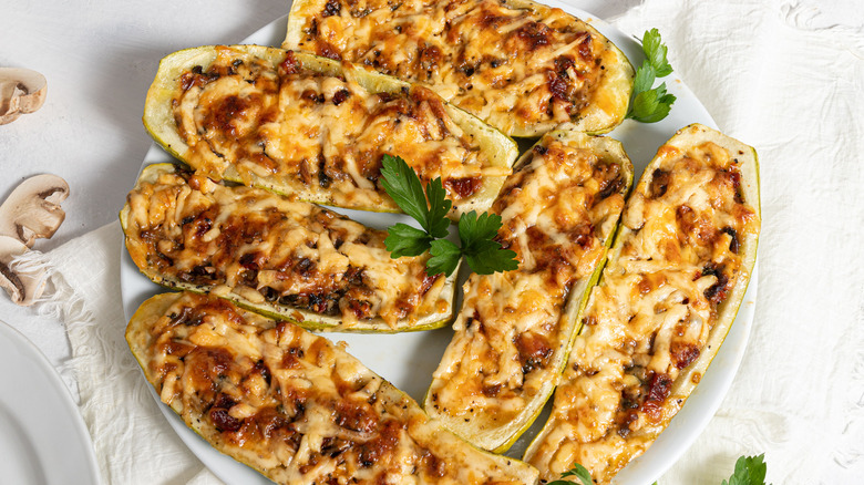 Cheesy zucchini boats on a plate.