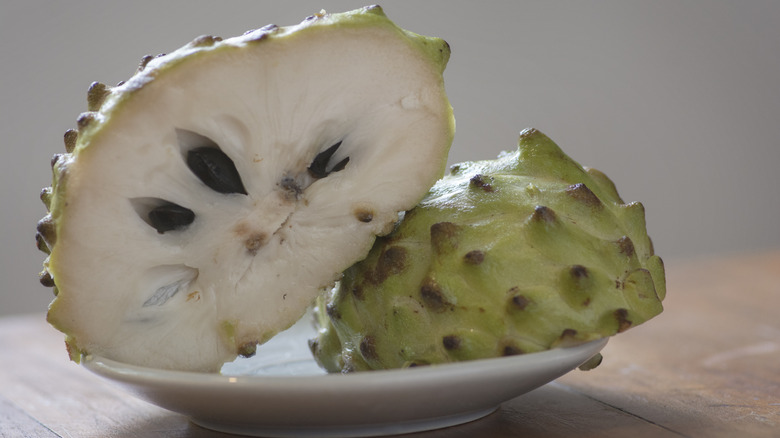 cherimoya sliced in half on a plate