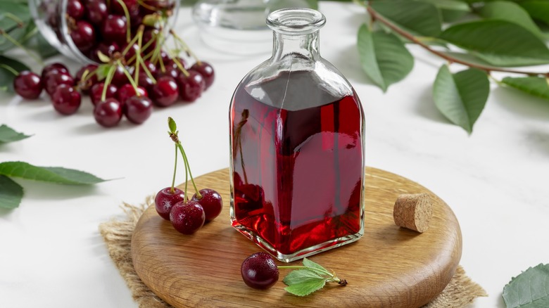 Bottle of cherry brandy and bunches of cherries