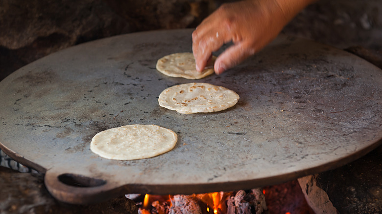 Hand flipping fresh tortillas