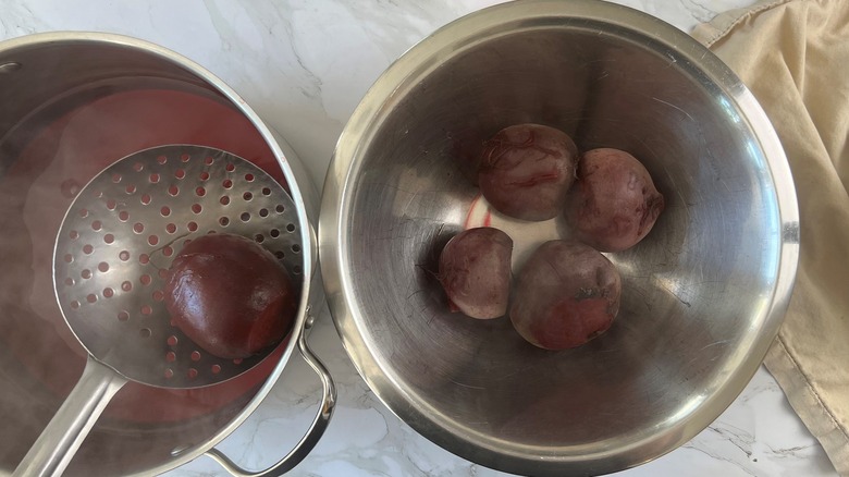ladling cooked beets into pot