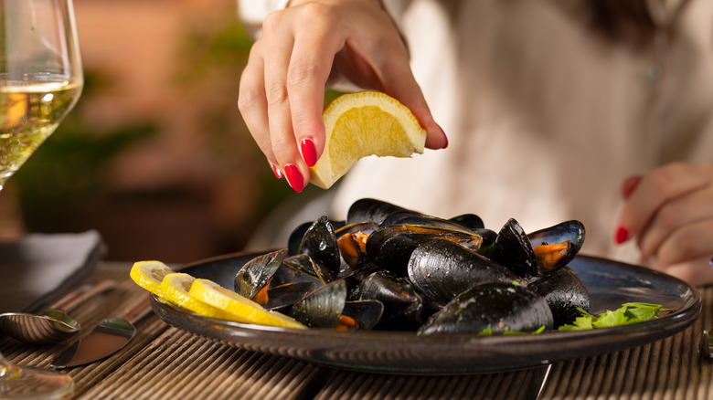 squeezing lemon over mussels 