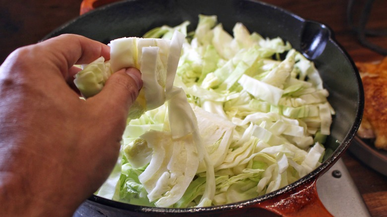 placing sliced cabbage in pan