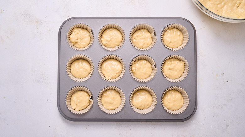 filling muffin tins with batter