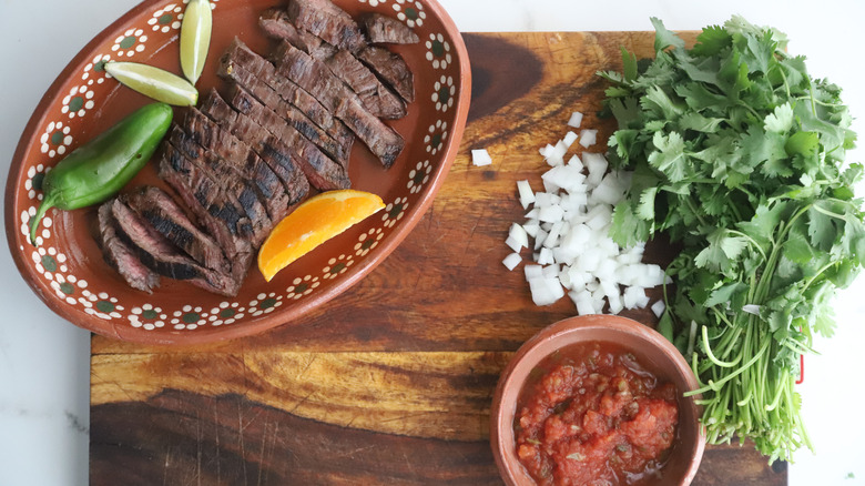 Sliced steak and taco accompaniments