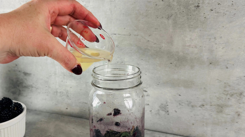 Lime juice pouring into glass jar