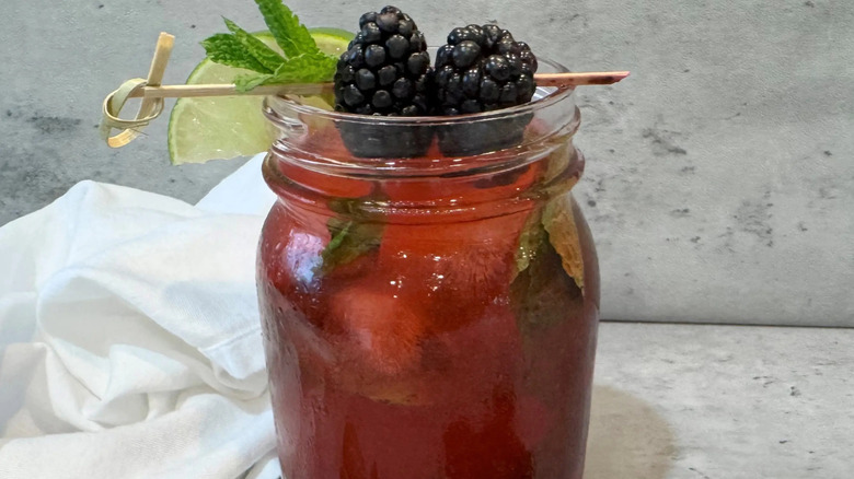 Blackberry mojito in jar with garnishes