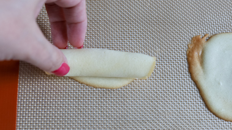 rolled-up cookie and fingers