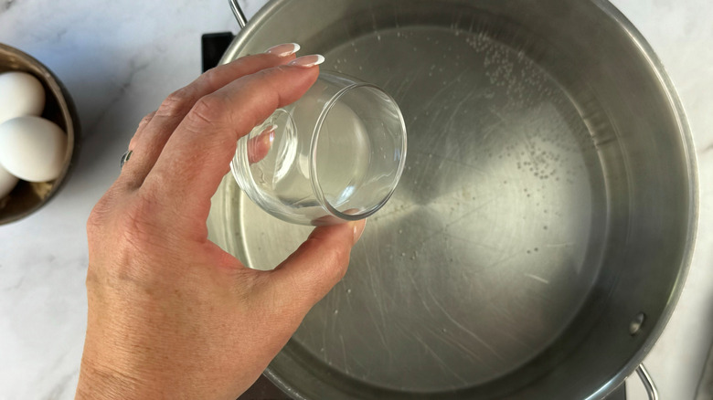 adding vinegar to water in pot