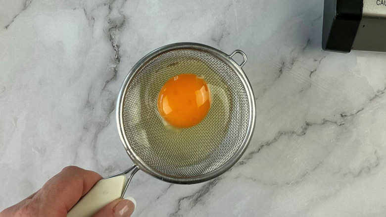 raw egg in strainer