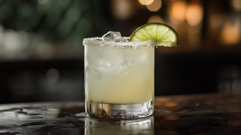 A classic margarita with a slated rim and a lime wedge