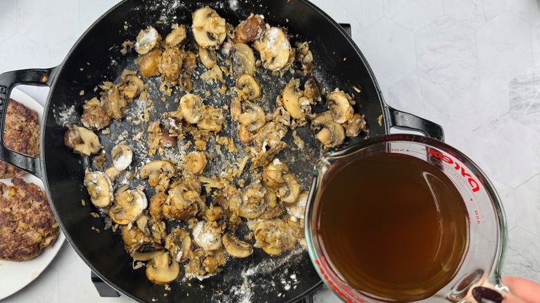 pouring broth into pan with sauteed mushrooms