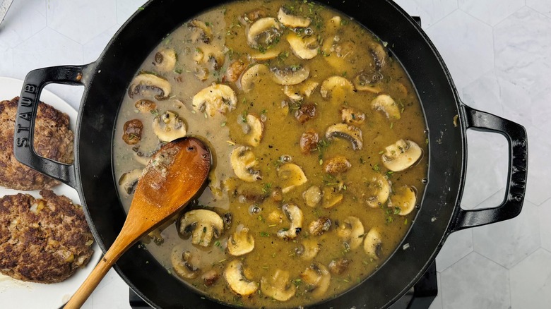 simmering broth with mushrooms in skillet