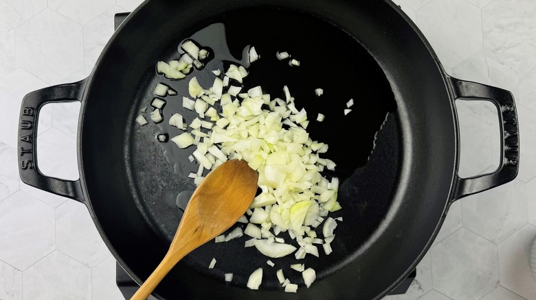 stirring chopped onions with oil in skillet