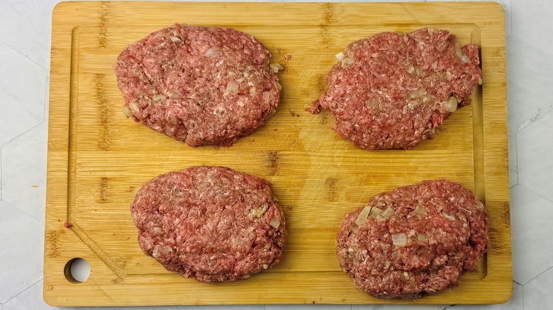 shaped beef patties on wooden cutting board