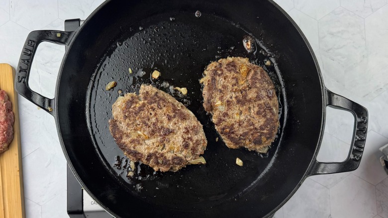 two browned beef patties in skillet