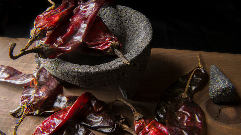 mortar and pestle with chilis on kitchen counter