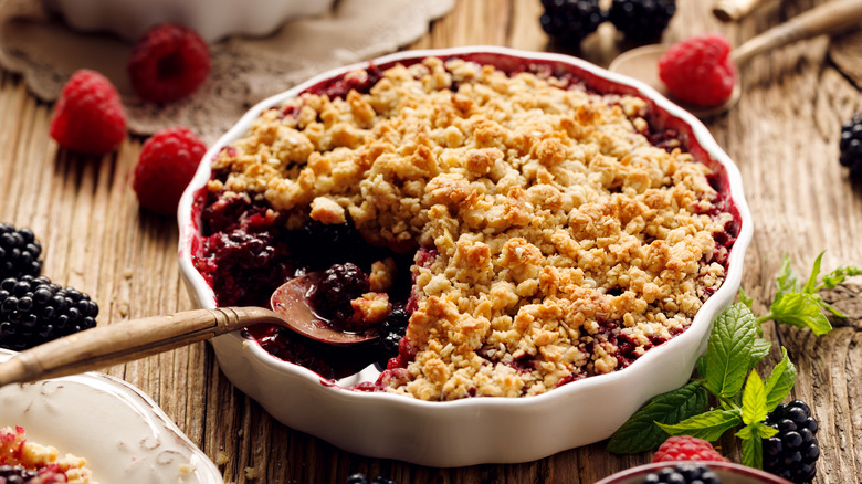 Berry crumble fruit pie with streusel topping in round white dish