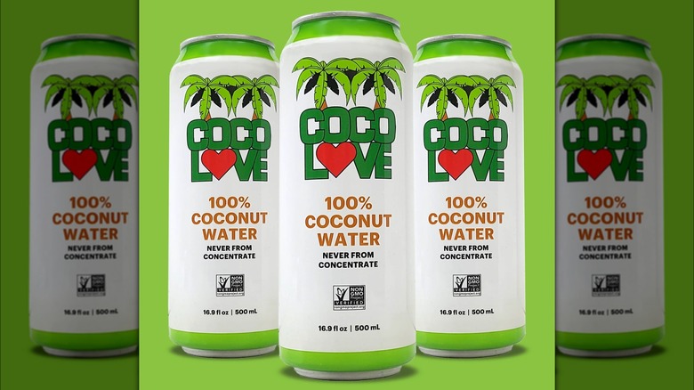 Three cans of CocoLove coconut water on green background