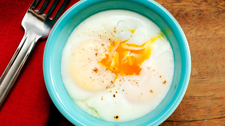 A bowl of coddled eggs with runny yolks