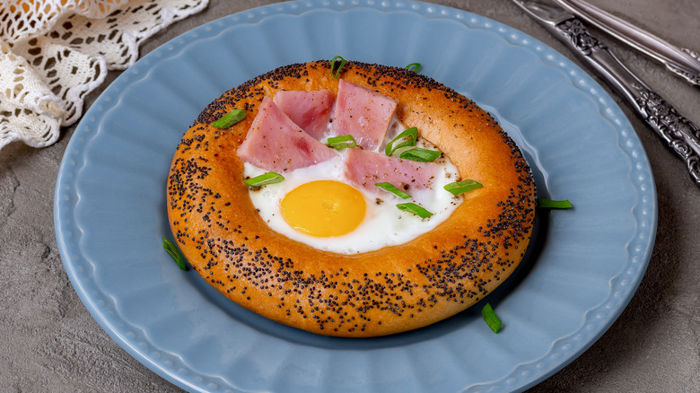 A bagel egg in a hole with sliced ham