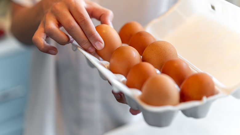 Person choosing egg from carton