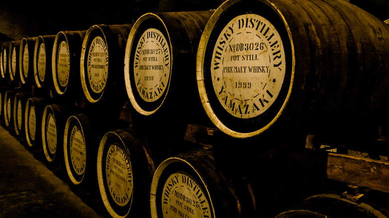 Japanese whisky barrels lining the wall of a distillery