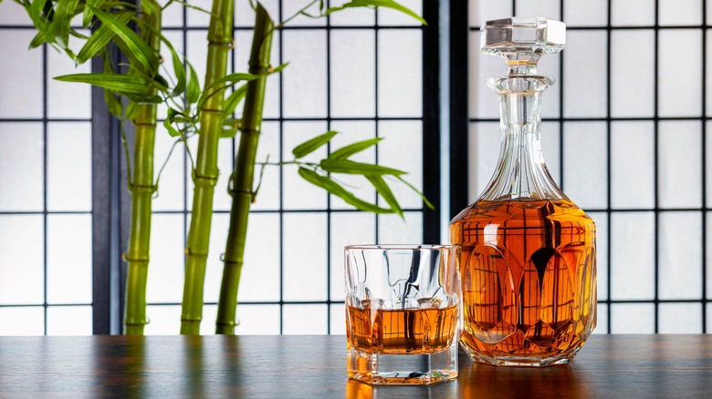 Crystal glass and decanter full of whisky with nearby bamboo