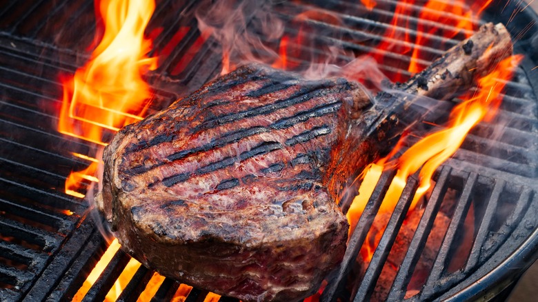 Steak cooking on charcoal grill