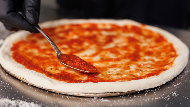 Pizza sauce placed on pizza dough