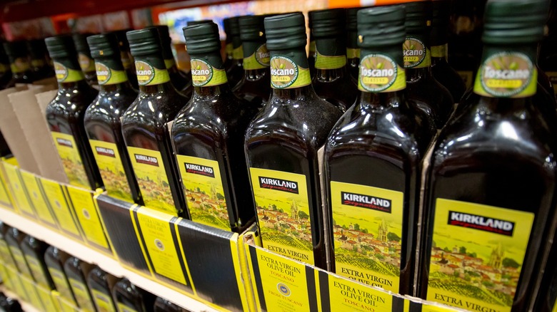 Bottles of Kirkland Signature Extra Virgin Olive Oil on shelves.