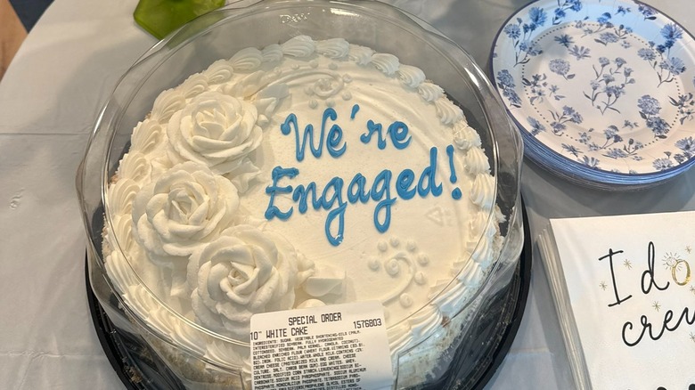 Costco custom cake, reads "We're engaged!"