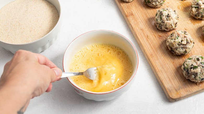 Hand whisking eggs in bowl